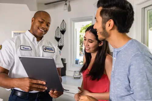 Benjamin Franklin Plumbing Tech, Trevor, speaking with homeowners at their home in Lakeland FL